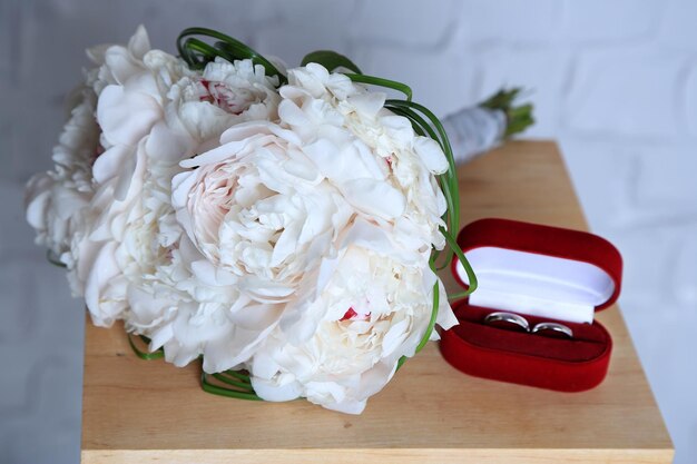 Beautiful wedding bouquet on   wooden stand on light wall background