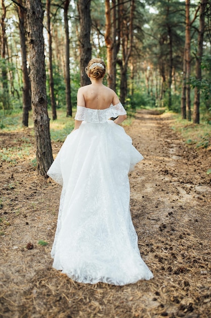 庭で走っている美しい結婚式の花嫁。