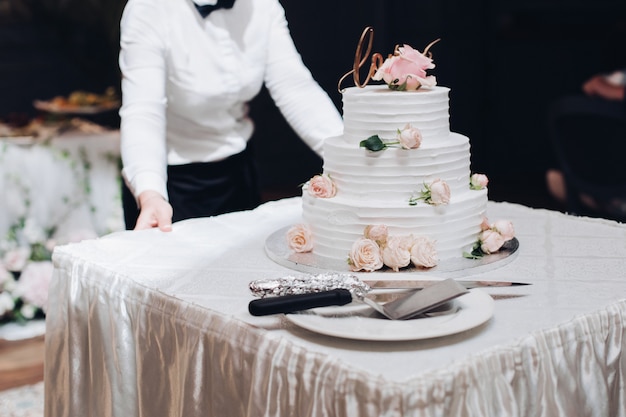 Bella torta nunziale con i fiori sul tavolo