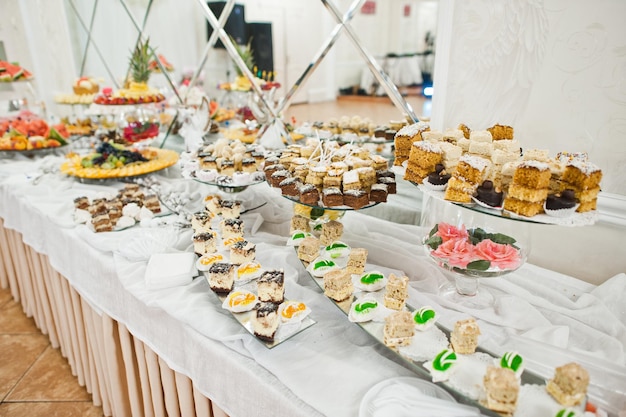 Beautiful wedding candy bar with sweets fruits and food Wedding banquet table