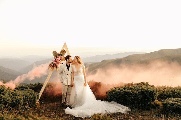 Фото Красивая свадебная церемония в горах, свадебная пара влюбленных молодоженов.