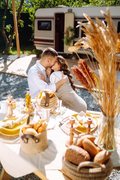 Beautiful wedding couple laugh and kiss relaxing in rv camping in a trailer Romantic moment