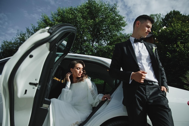 Beautiful wedding couple near the car