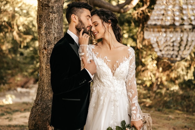 Bel matrimonio coppia di sposi che abbracciano sullo sfondo della foresta.