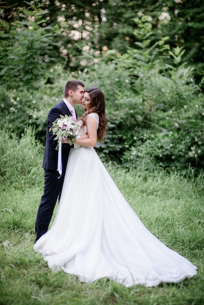 Premium Photo | Beautiful wedding couple poses in a green garden