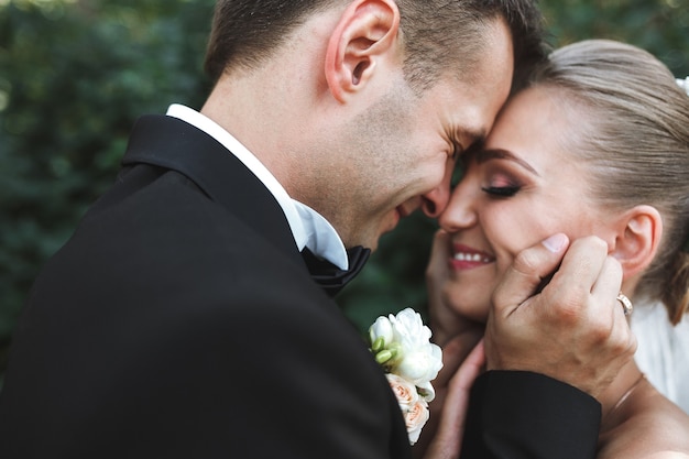 公園でポーズをとって美しい結婚式のカップル