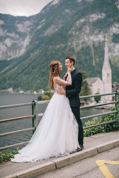 A beautiful wedding couple walks on a background old cathedral in a fairy Austrian town