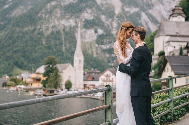 A beautiful wedding couple walks on a background old cathedral in a fairy Austrian town