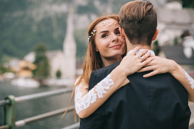 A beautiful wedding couple walks on a background old cathedral in a fairy Austrian town