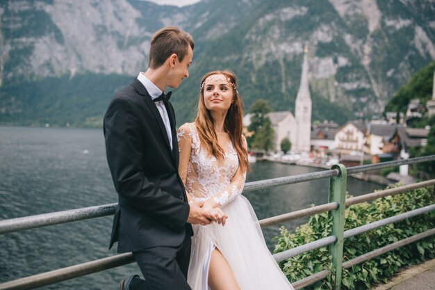 A beautiful wedding couple walks on a background old cathedral in a fairy Austrian town