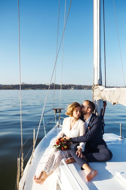Beautiful wedding couple on yacht at wedding day outdoors in the sea together wedding day