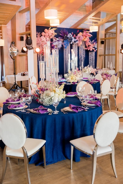 Beautiful wedding decor in blue and purple tones Wedding table decoration flowers plates glasses