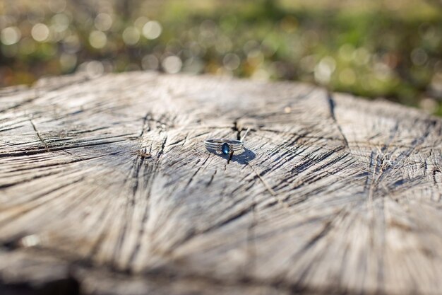 Beautiful wedding ring with white gold and a large blue stone on wood