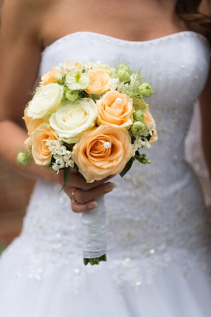 Beautiful wedding roses bouquet in hands of the bride