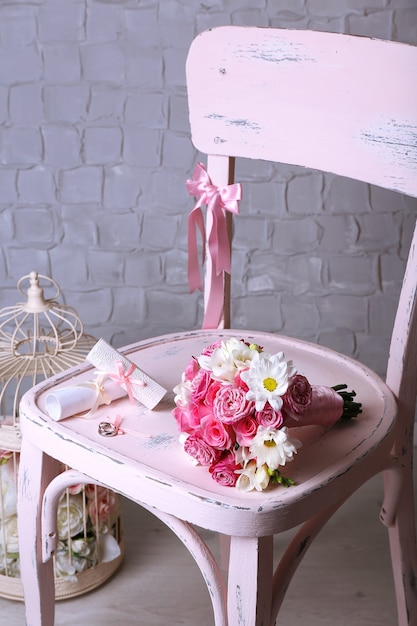 Photo beautiful wedding still life with bouquet on wooden chair