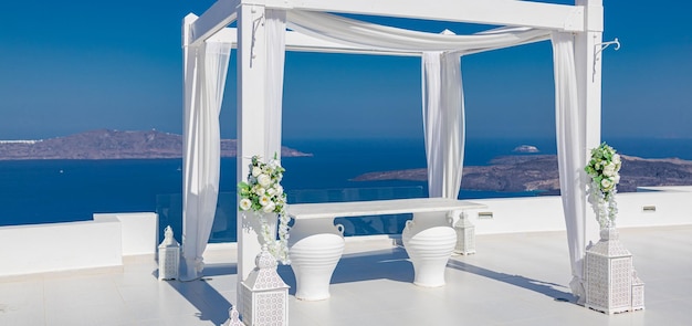 Beautiful wedding tent on Santorini island blue sky white decoration flowers on marble terrace