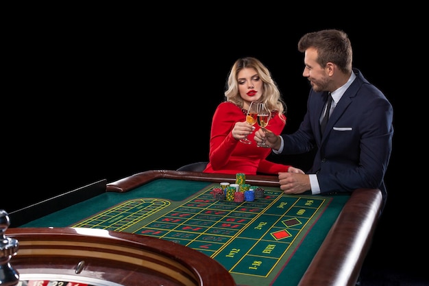 Beautiful and well dressed couple playing roulette in the casino