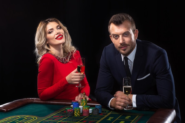 Beautiful and well dressed couple playing roulette in the casino