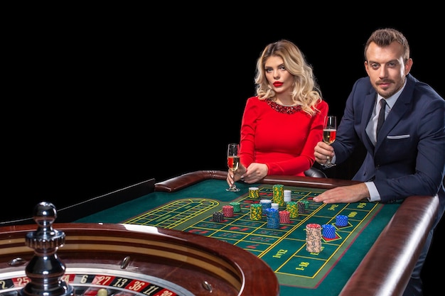 Beautiful and well dressed couple playing roulette in the casino