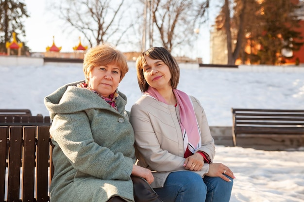 Beautiful wellgroomed middleaged women on bench in spring park