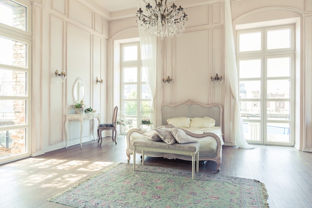 Beautiful white bright clean interior bedroom in luxurious baroque style.