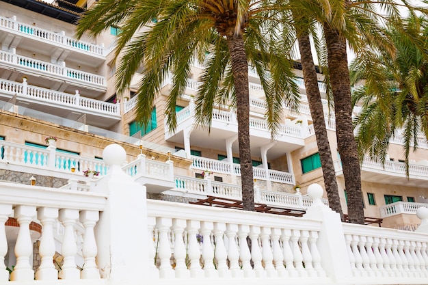 Beautiful white building in antique style among palm trees