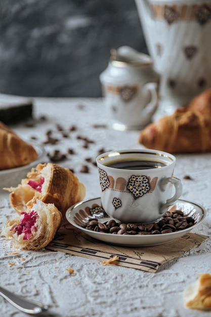 Bella tazza di caffè bianca caffè caldo per colazione croissant freschi con caffè al cioccolato spi
