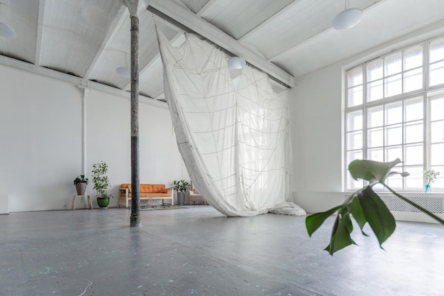 Beautiful white interior of the spacious room with hanging parachute