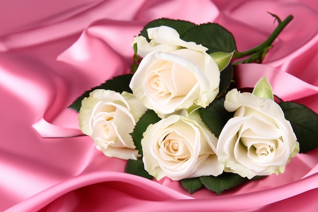 Beautiful white roses on pink satin close up