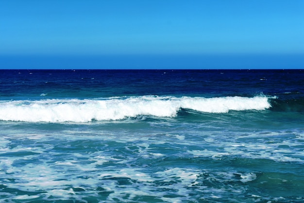 beautiful white waves foam ingested in blue water