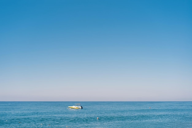 明るい晴れた夏の日に青い海の美しい白黄色のボート