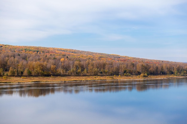 Beautiful, wide autumn river among forests and rocky shore A calm and quiet place with autumn colors