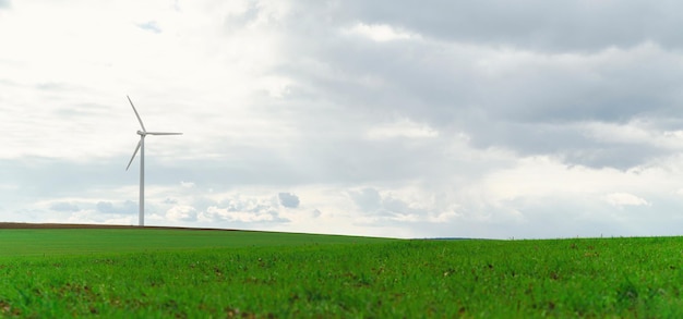 Beautiful wide shot of a single wind turbine standing on a green meadow