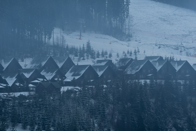 Beautiful winter landscape in the mountain village. Foggy morning