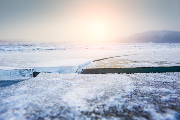 Beautiful winter landscape with ice on the lake at sunset. Small depth of sharpness. Winter background