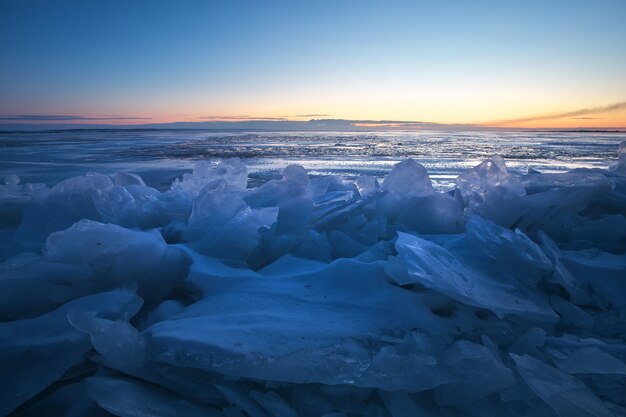 Beautiful winter landscape with sunset sky and frozen lake