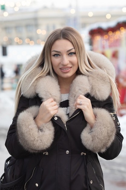 Beautiful winter portrait of young woman in the winter snowy scenery