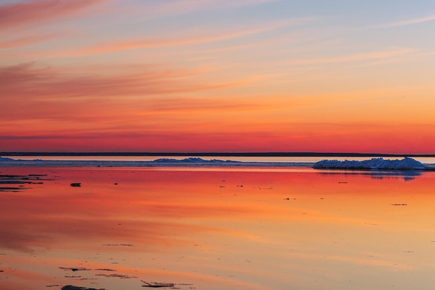 Photo beautiful winter sunset by the sea with iceberg