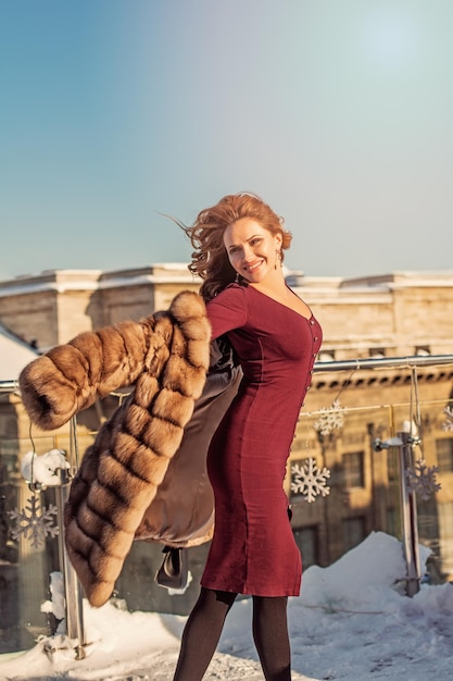 Bella donna invernale in cappotto che si gode il sole invernale all'aperto