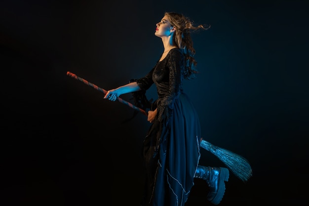 Photo a beautiful witch on a broomstick is flying to the sabbath