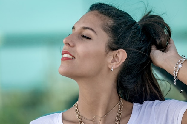 Beautiful woman adjusting hairdo and smiling