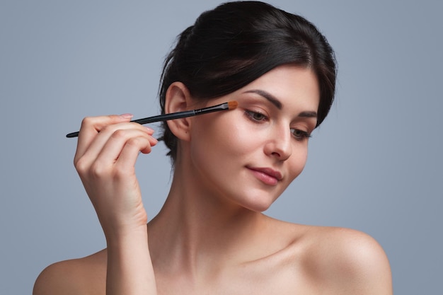 Photo beautiful woman applying eyeshadow