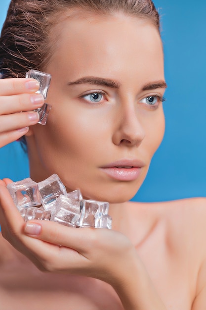 Beautiful woman applying ice cube treatment  