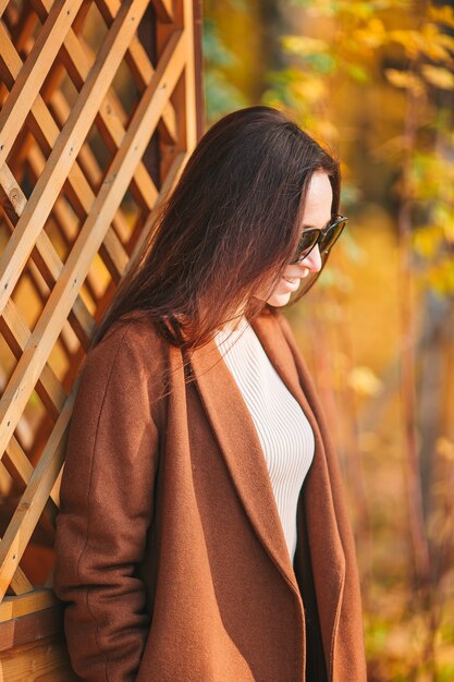 Beautiful woman in autumn park under fall foliage