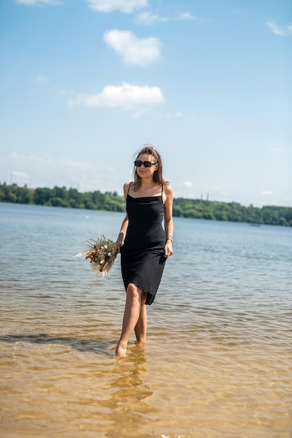 Beautiful woman barefoot walks by the lake warm water relaxation and rest