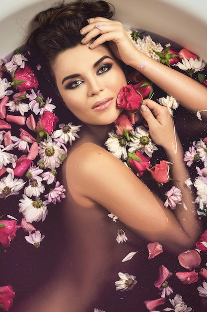 Beautiful woman in the bath with flowers