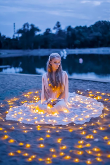 Beautiful woman at the beach with garland lights