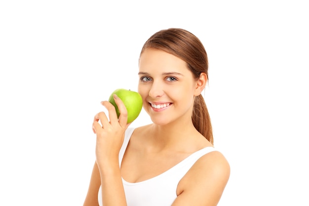 beautiful woman biting a green apple on white background