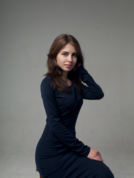 Beautiful woman in a black dress over gray 