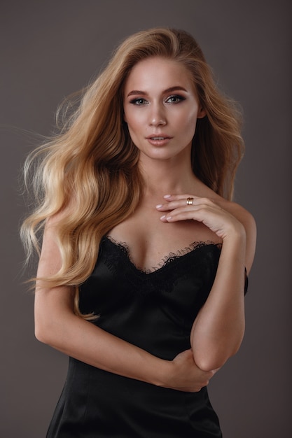 Beautiful woman in black dress in studio